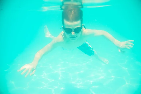 Un petit garçon nageant sous l'eau dans la piscine — Photo