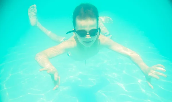 Un petit garçon nageant sous l'eau dans la piscine — Photo