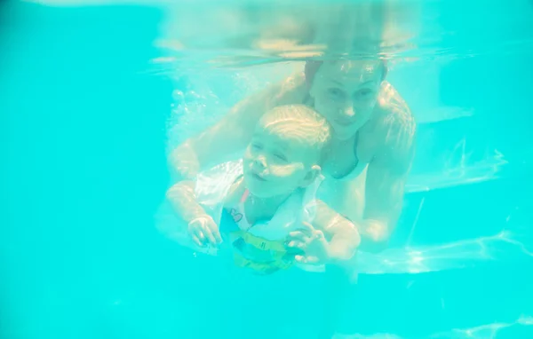 Suya bir bebek ile anne dalışlar — Stok fotoğraf
