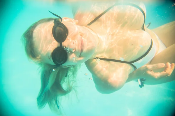 Nő a víz alatti úszás a medencében — Stock Fotó
