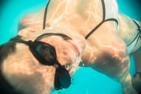 Mujer nadando bajo el agua en la piscina — Foto de Stock