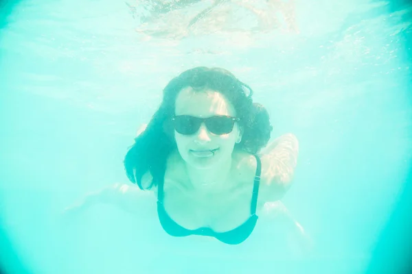 Dívka, plavání pod vodou v sluneční brýle — Stock fotografie