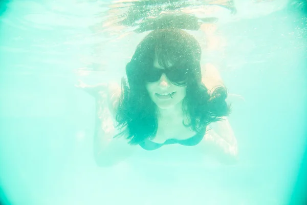 Mädchen schwimmt mit Sonnenbrille unter Wasser — Stockfoto