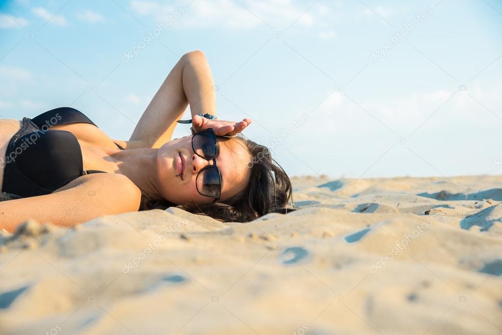 Girl in black swimsuit jumping on the background of the desert