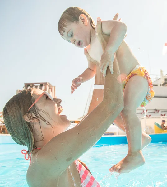 Mladá matka, koupání v bazénu s vaším dítětem — Stock fotografie