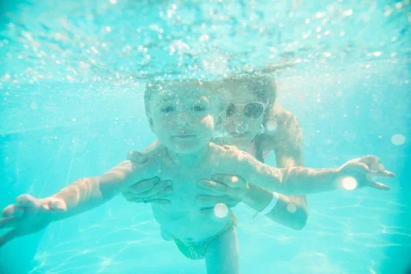 Madre joven nada bajo el agua con su hijo — Foto de Stock