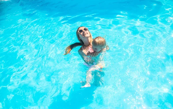 Jovem mãe tomando banho na piscina com seu filho — Fotografia de Stock