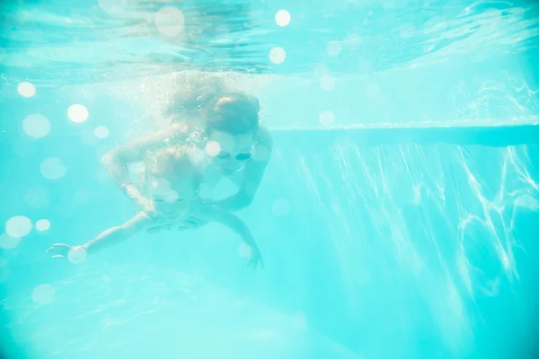 Jovem mãe nada debaixo d 'água com seu filho — Fotografia de Stock