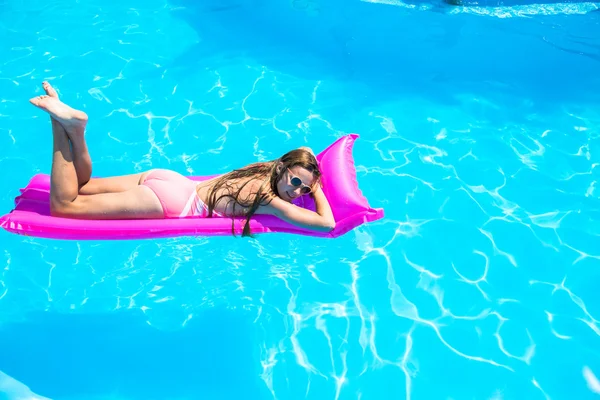 The girl floats on an inflatable mattress in the pool — Stock Photo, Image