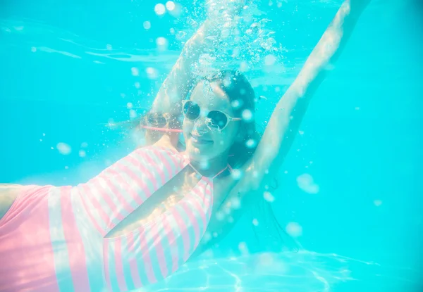 Junges Mädchen mit Sonnenbrille schwimmt unter Wasser — Stockfoto