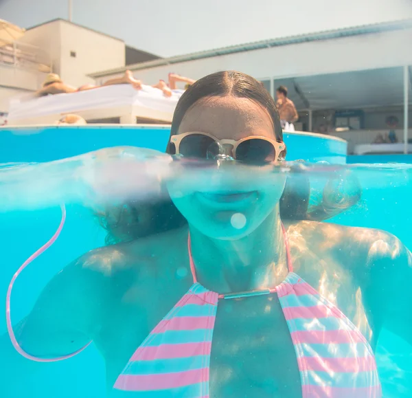 Chica joven en gafas de sol nadando bajo el agua —  Fotos de Stock
