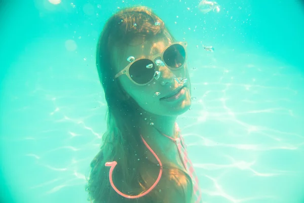 Νεαρό κορίτσι σε γυαλιά ηλίου κολύμβηση υποβρύχια — Φωτογραφία Αρχείου