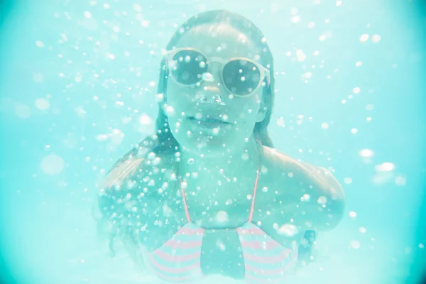 Молодая девушка в солнечных очках плавает под водой — стоковое фото