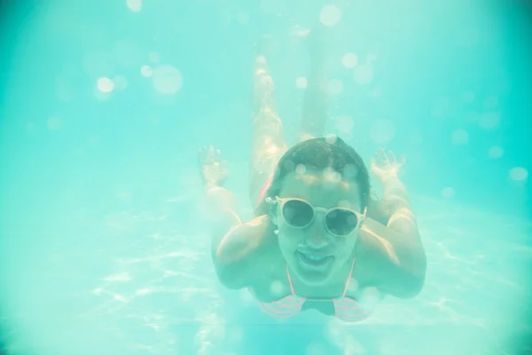 Junges Mädchen mit Sonnenbrille schwimmt unter Wasser — Stockfoto