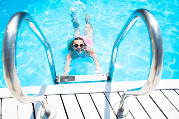 Chica nada en la piscina al aire libre — Foto de Stock