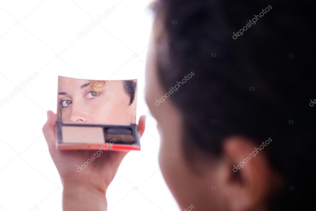 Women's eyes are looking in her compact