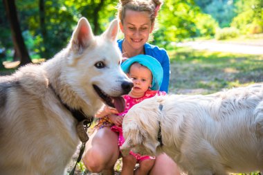 My mother with a small child playing with other people's dogs clipart