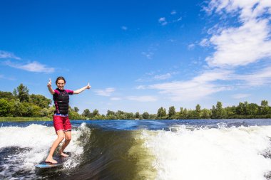 Girl rides a study wakesurfing clipart