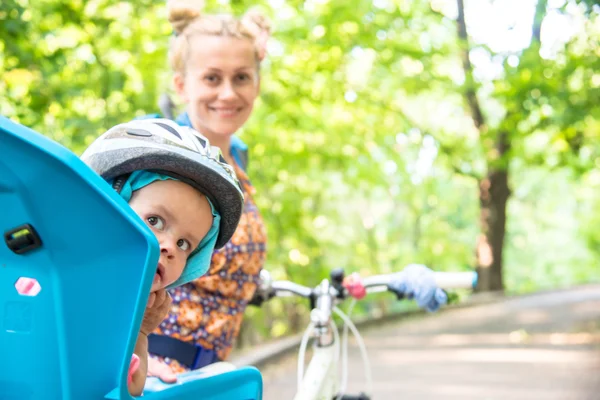 自転車のヘルメットを身に着けていた小さい子供が付いているバイクのお母さんと — ストック写真