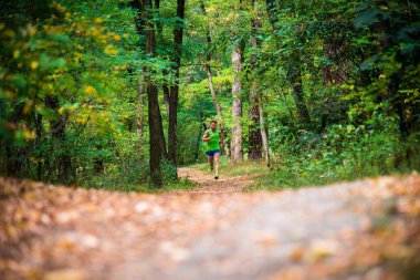 Ağaçların arasından koşan adam