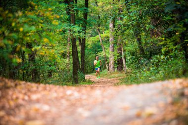 Ağaçların arasından koşan adam