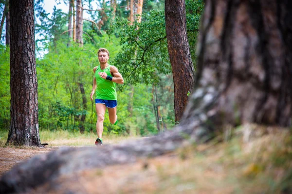 Um atleta correndo pela floresta — Fotografia de Stock