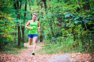 Ağaçların arasından koşan adam