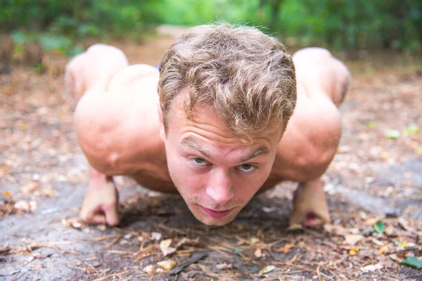 Man doing exercises in the woods — Stockfoto