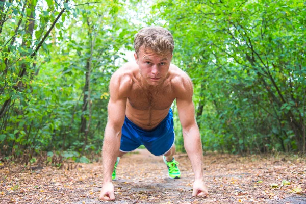 Man doing exercises in the woods — Stockfoto