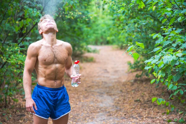 Чоловік п'є воду після пробігу банків . — стокове фото