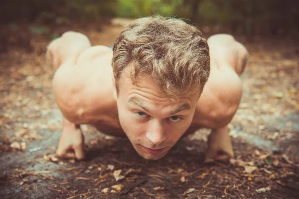 Man doing exercises in the woods — 图库照片