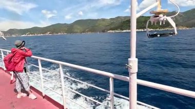 A tourist stands on the deck and sails to Elba Island.
