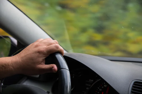 Ludzką ręką trzyma koło samochodu. — Zdjęcie stockowe
