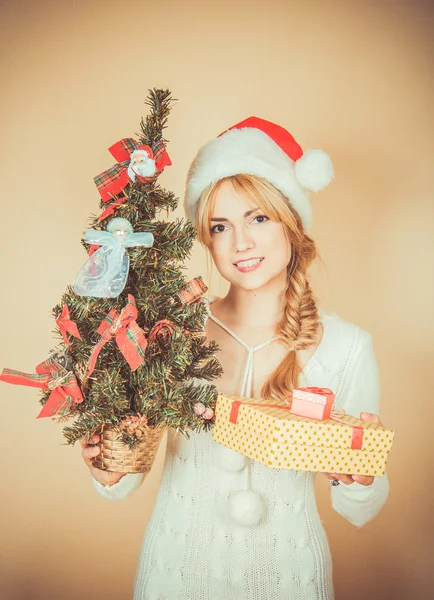 Дівчина в капелюх Санта Клауса з ялинку і gif — стокове фото