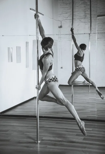 Pole Dance. Turnerin turnte Übungen auf dem Pylon. schwarz-gelb — Stockfoto