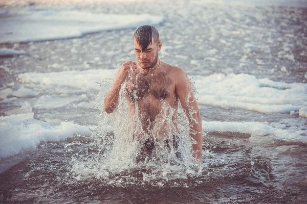 Een jonge jongen baadt in het ijskoude water. De christelijke feestdag van — Stockfoto