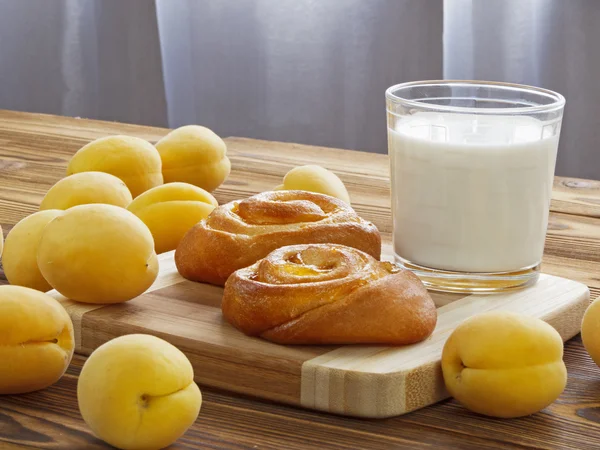Brötchen mit Aprikosen und Milch lizenzfreie Stockbilder