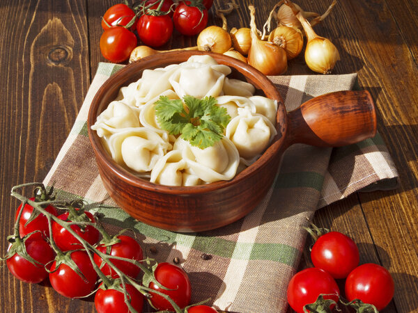 Пельмени с мясом на деревянном столе
