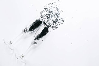 Beyaz arka planda yıldız şeklinde siyah konfetili şampanya bardakları. Düz konum, üst görünüm, kopyalama alanı. Kutlama ve kutlama konsepti. Kara Cuma İndirim geçmişi.