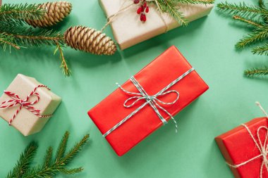 Noel ya da yeni yıl kompozisyonu hediye kutuları, yeşil arka planda köknar dalları. Düz yerde, üst tarafta. Mutlu Noeller kartı.