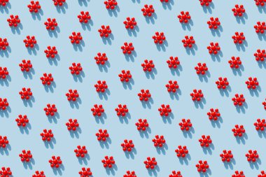 Mavi arka planda kırmızı koronavirüs modelleri. Coronavirus veya COVID-19, 2019-NCov koruması. Renkli salgın ya da salgın hastalık desenli konsept. Düz yatış, üst görünüm