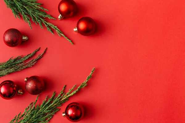 Roter Weihnachtskugelschmuck Und Baumzweige Auf Rotem Hintergrund Neujahrsgrußkarte Minimaler Stil — Stockfoto