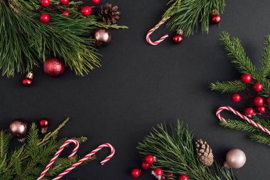 Noel süslemeleri ve siyah arka planda Xmas ağacı dalları. Yeni yıl tebrik kartı. uzanma, üst görünüm, kopyalama alanı.