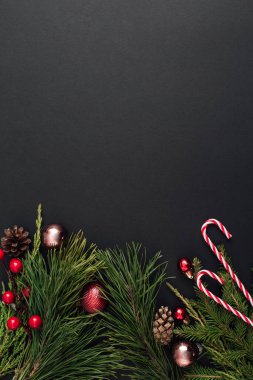 Noel süslemeleri ve siyah arka planda Xmas ağacı dalları. Yeni yıl tebrik kartı. uzanma, üst görünüm, kopyalama alanı.