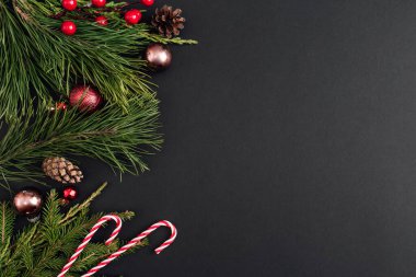 Noel süslemeleri ve siyah arka planda Xmas ağacı dalları. Yeni yıl tebrik kartı. uzanma, üst görünüm, kopyalama alanı.