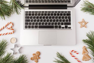 Noel, kış, yeni yıl kompozisyonu. Ofis masası çalışma alanı, firavun ağacı dalları, zencefilli ekmek, şekerler, beyaz arka planda mumlar. Düz yatış, üst görünüm