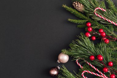 Noel süslemeleri ve siyah arka planda Xmas ağacı dalları. Yeni yıl tebrik kartı. uzanma, üst görünüm, kopyalama alanı.