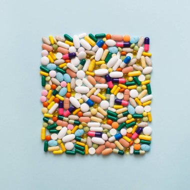 Mavi arka planda renkli hapların ve kapsüllerin yaratıcı tasarımı. Asgari tıbbi konsept. Eczacılık, Covid-19 veya Coronavirus. Düz yatış, üst görünüm