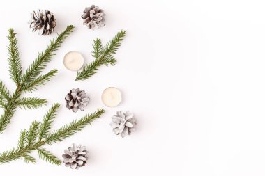 Noel, kış, yeni yıl kompozisyonu. Firavun ağacı dalları, köknar konisi, beyaz arka planda mumlar. Düz konum, üst görünüm, kopyalama alanı