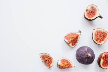 Yaratıcı dilimlenmiş desen ve beyaz arka planda olgun incirler. Meyve illüstrasyonu. Yemek fotoğrafı. Üst Manzara 'da dümdüz yatıyordu. Boşluğu kopyala.